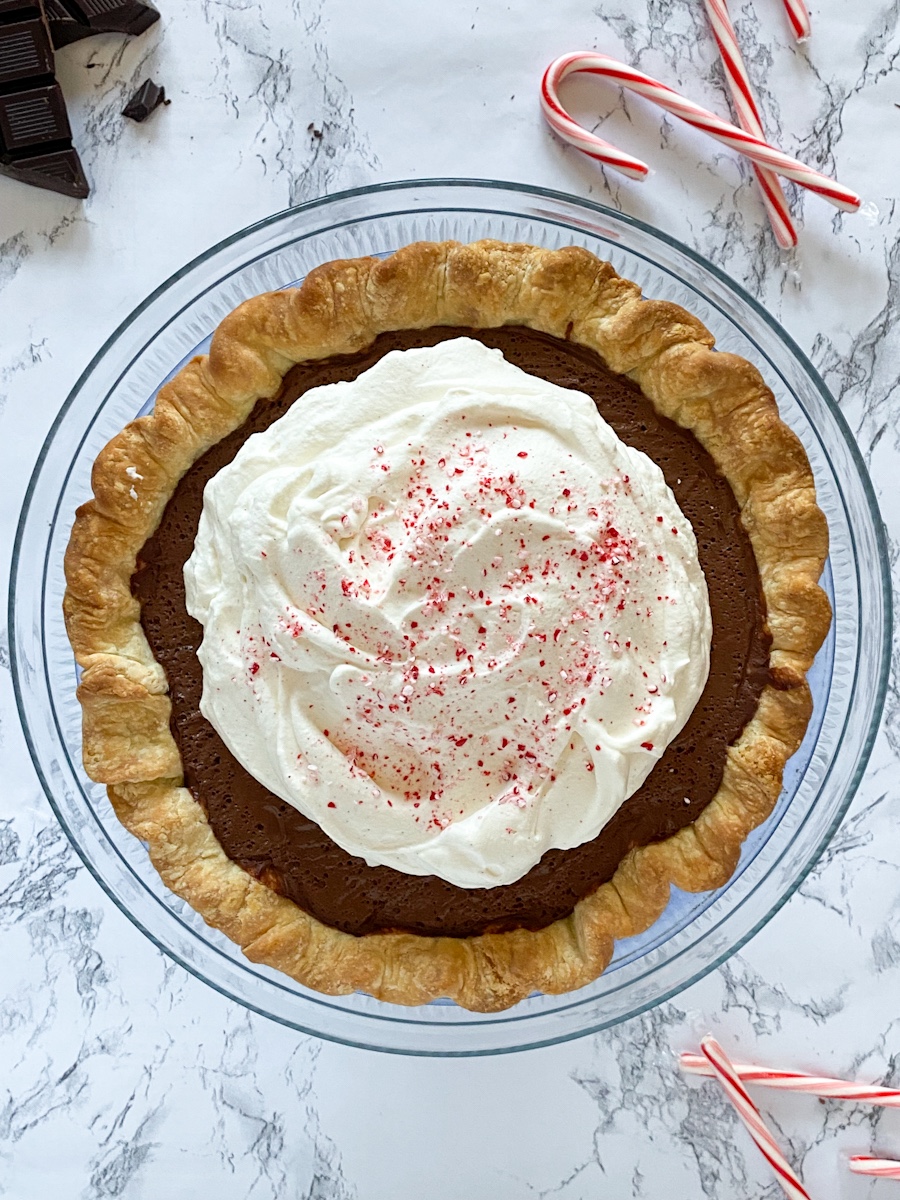 A chocolate peppermint pudding-filled pie topped with whipped cream and crushed candy canes.