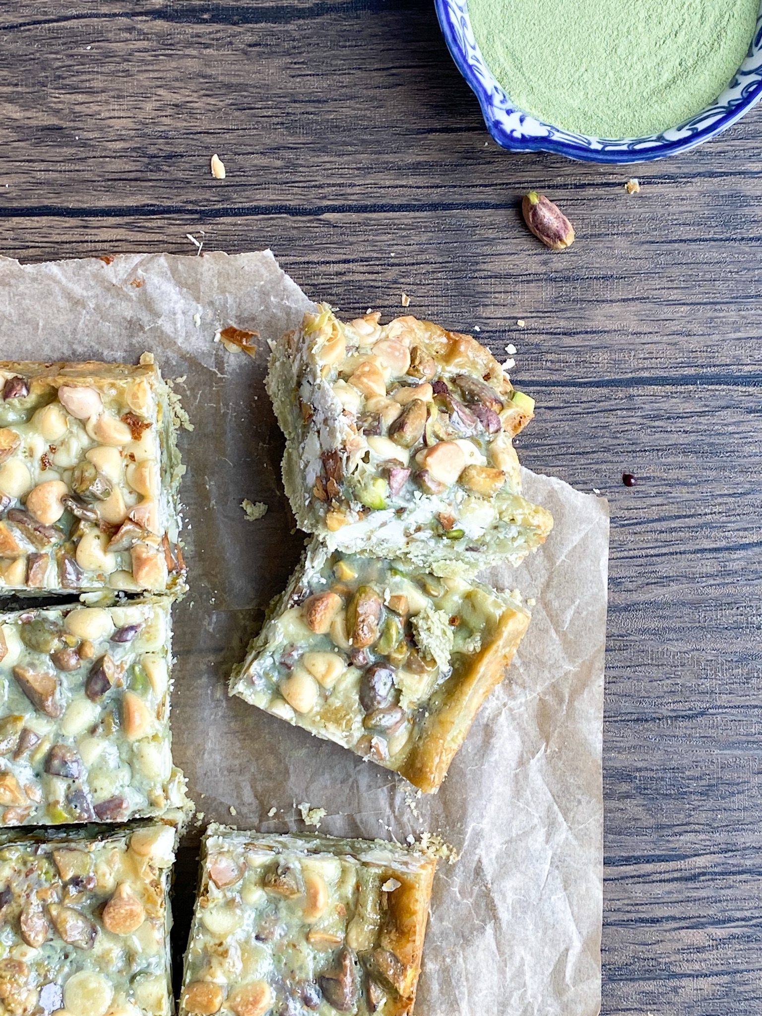 matcha 7-layer bars on parchment paper on top of a wooden surface.