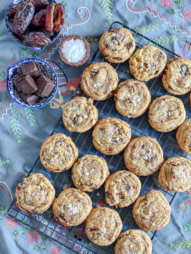 Cookies laid out on a cooling rack atop a blue tablecloth.